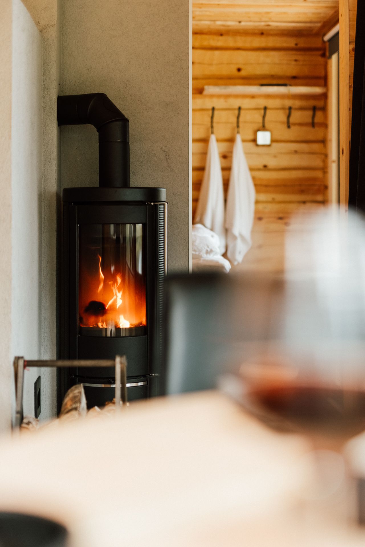 A fireplace with a glass of wine in the foreground