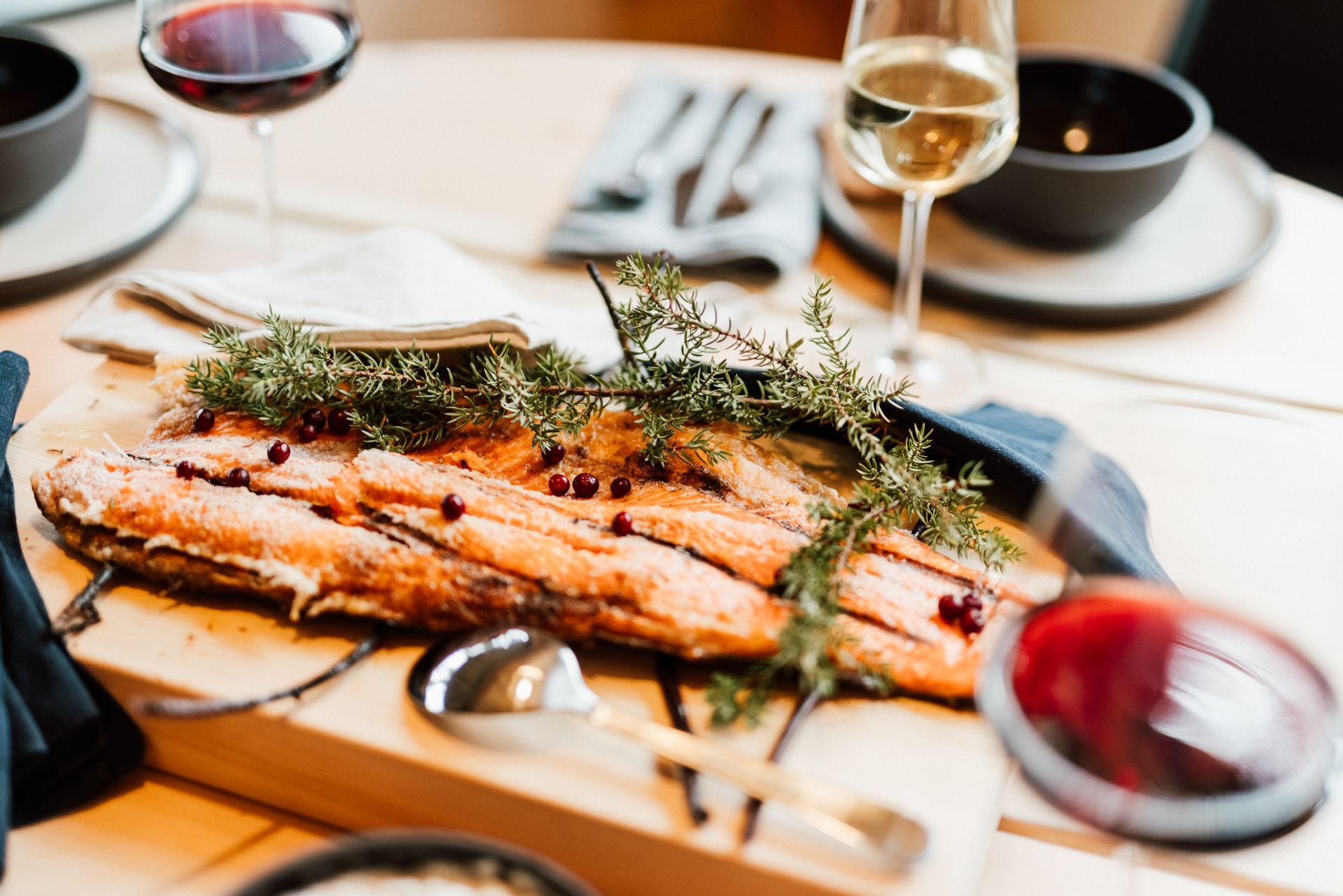 A large piece of salmon is sitting on a wooden cutting board on a table.