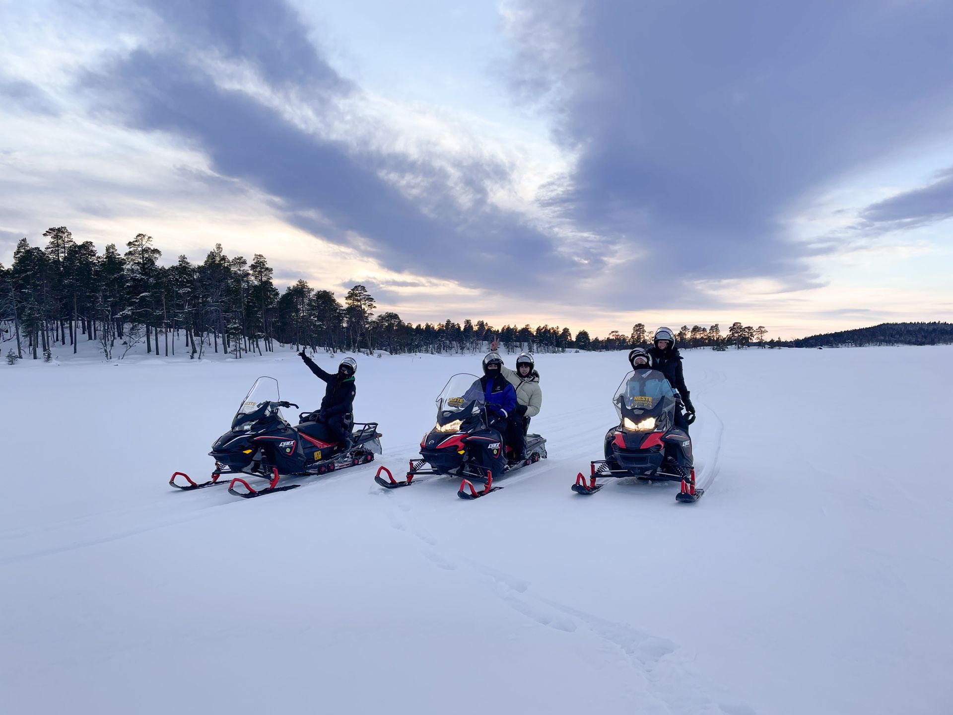 A group of people are riding snowmobiles in the snow.