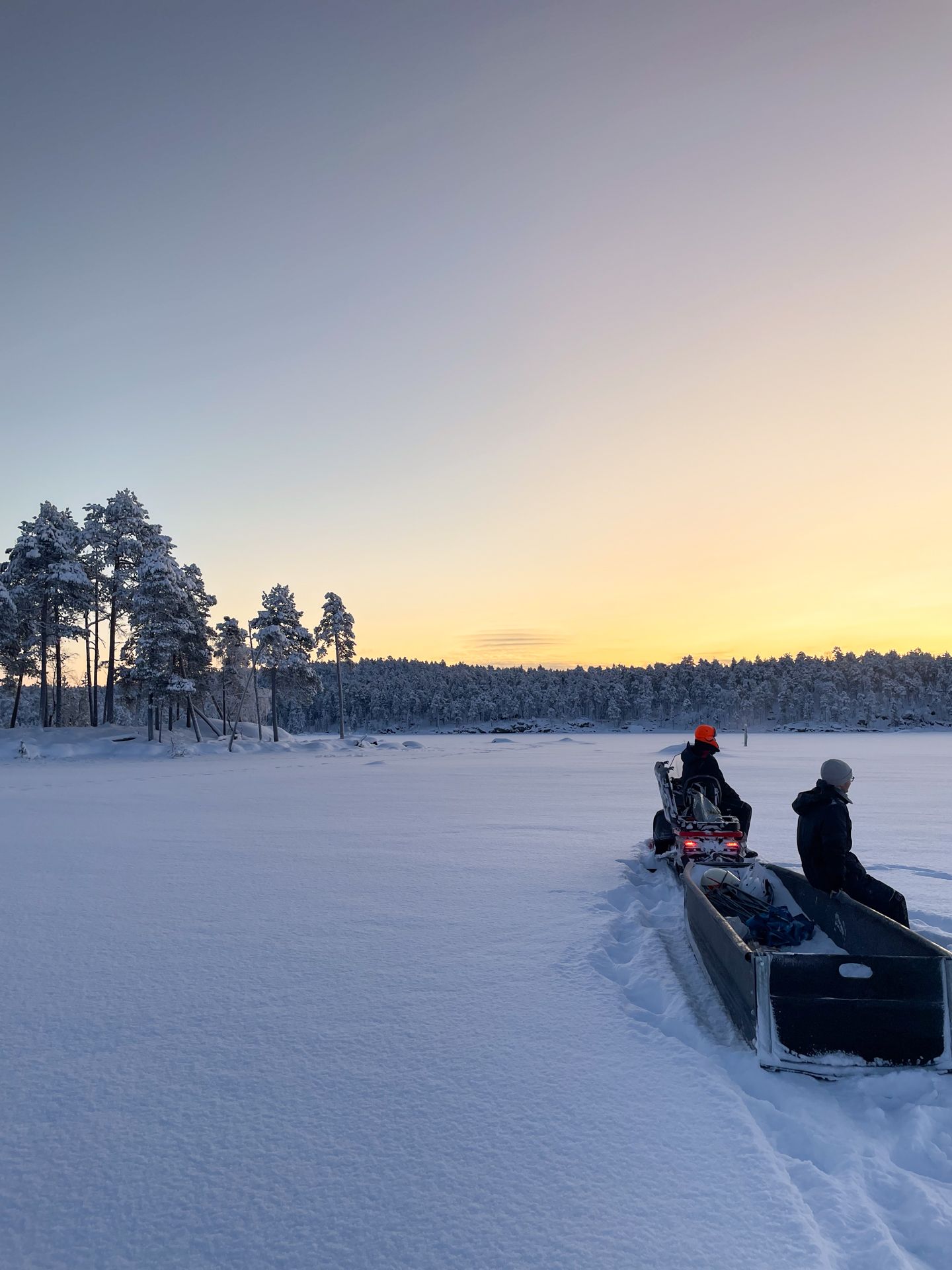 A group of people are riding a snowmobile on a snowy lake.