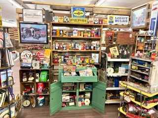 Small vintage candy and snack shop interior with shelves of colorful products and old displays