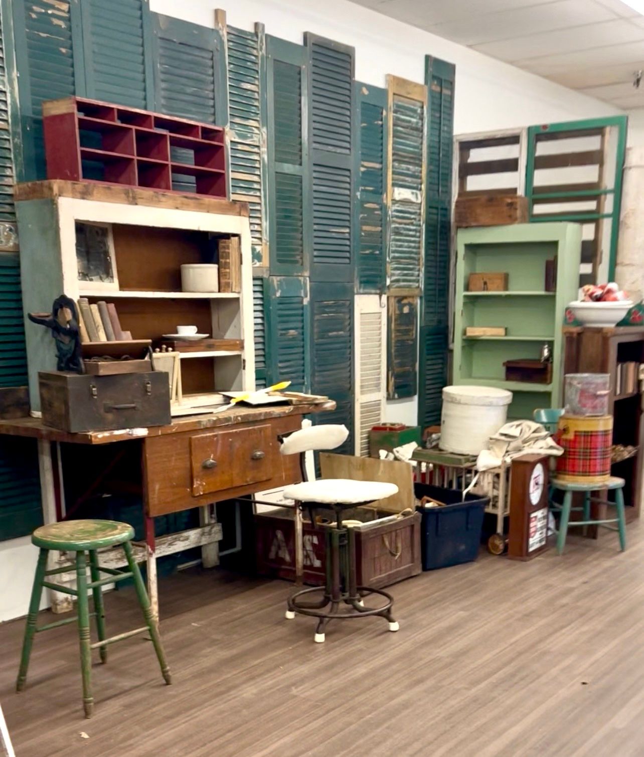 Vintage-style room with a wooden desk, stools, and colorful cabinets along the wall.