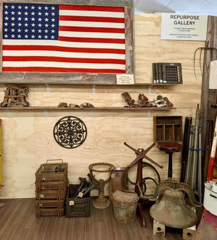 Rustic craft display with woven birdhouses, mossy greenery, and small decorative figures on wooden pallets