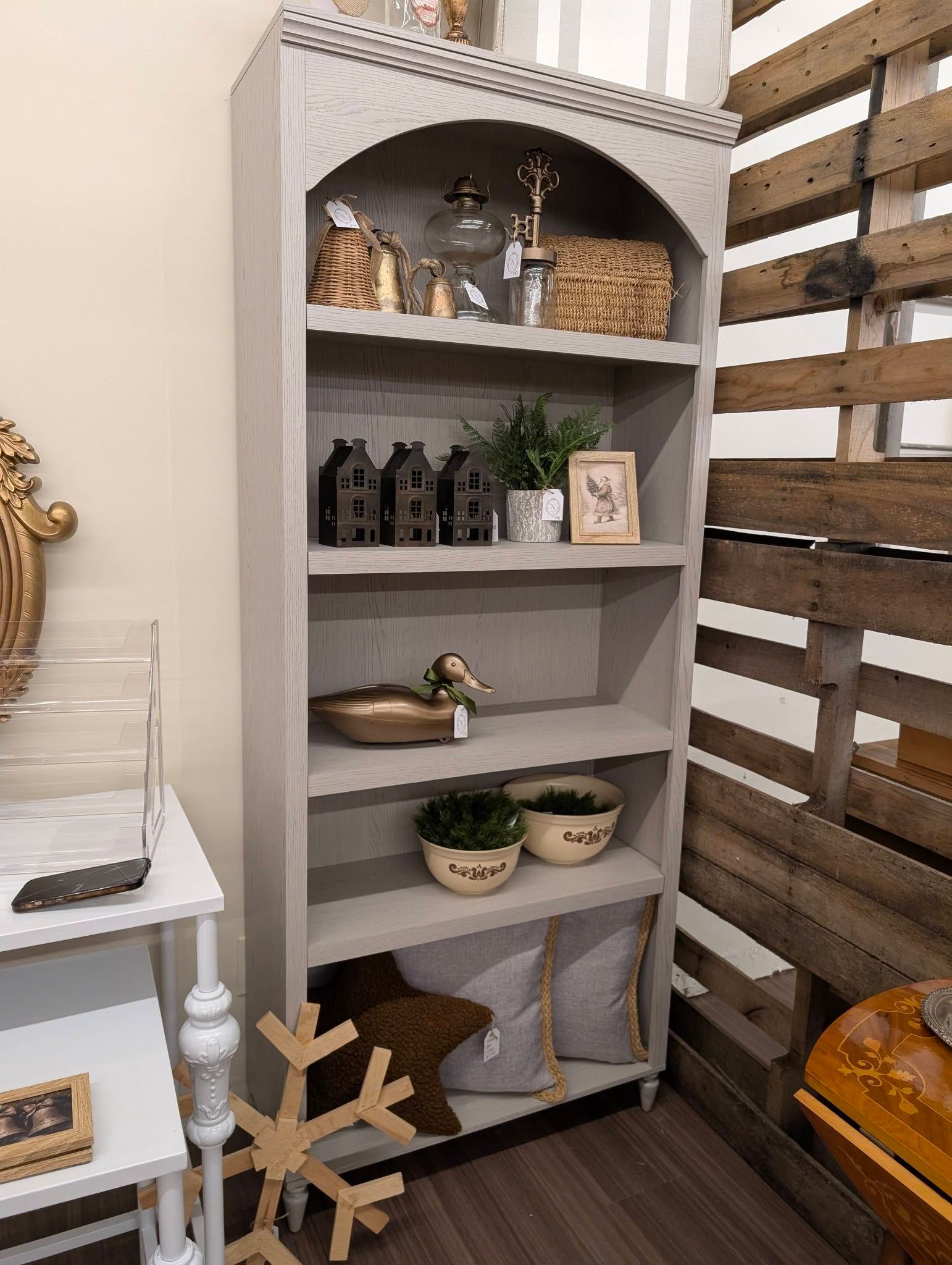 White shelf with decor and plants in a rustic room corner
