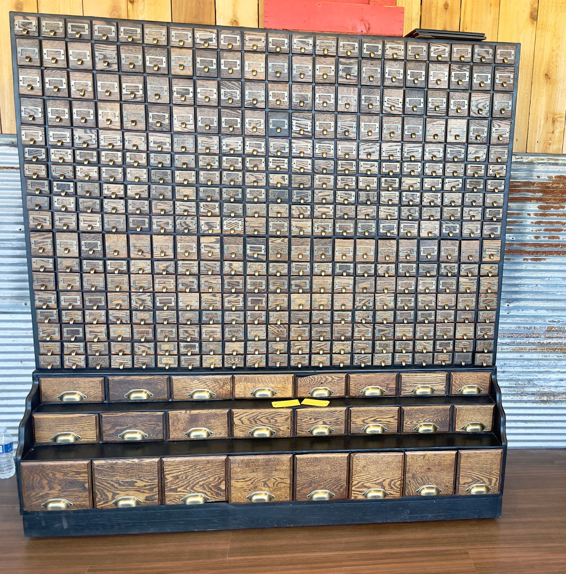 Wall of stacked seed packets in a wooden display rack, with larger bins of seeds along the bottom.