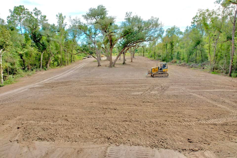 Dozer on cleared land, trees in the background. Construction in a wooded area.
