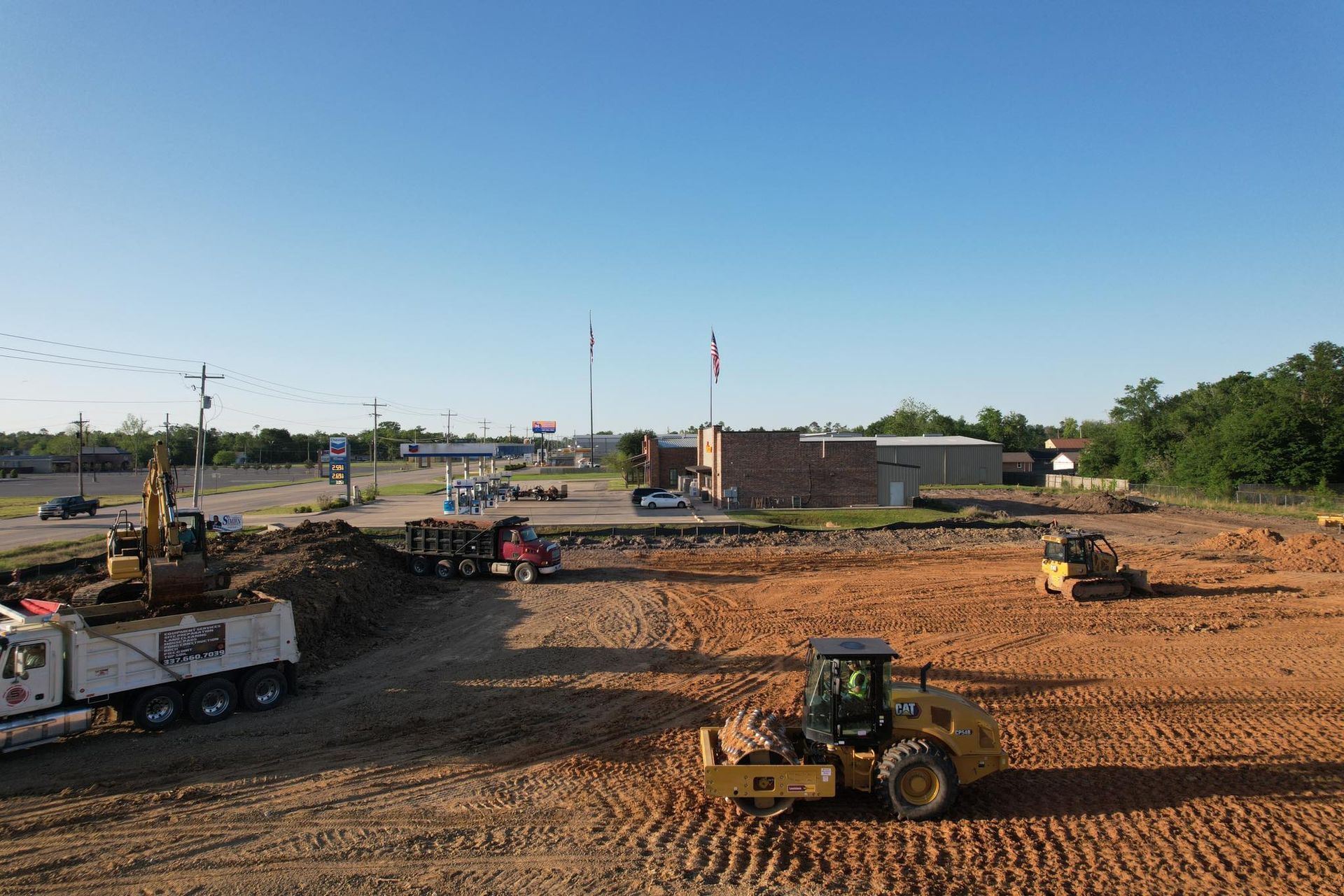 Construction site with heavy machinery, clear blue sky.