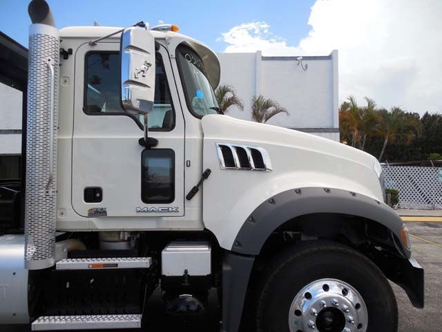White semi-truck cab with chrome details parked outdoors under a cloudy sky