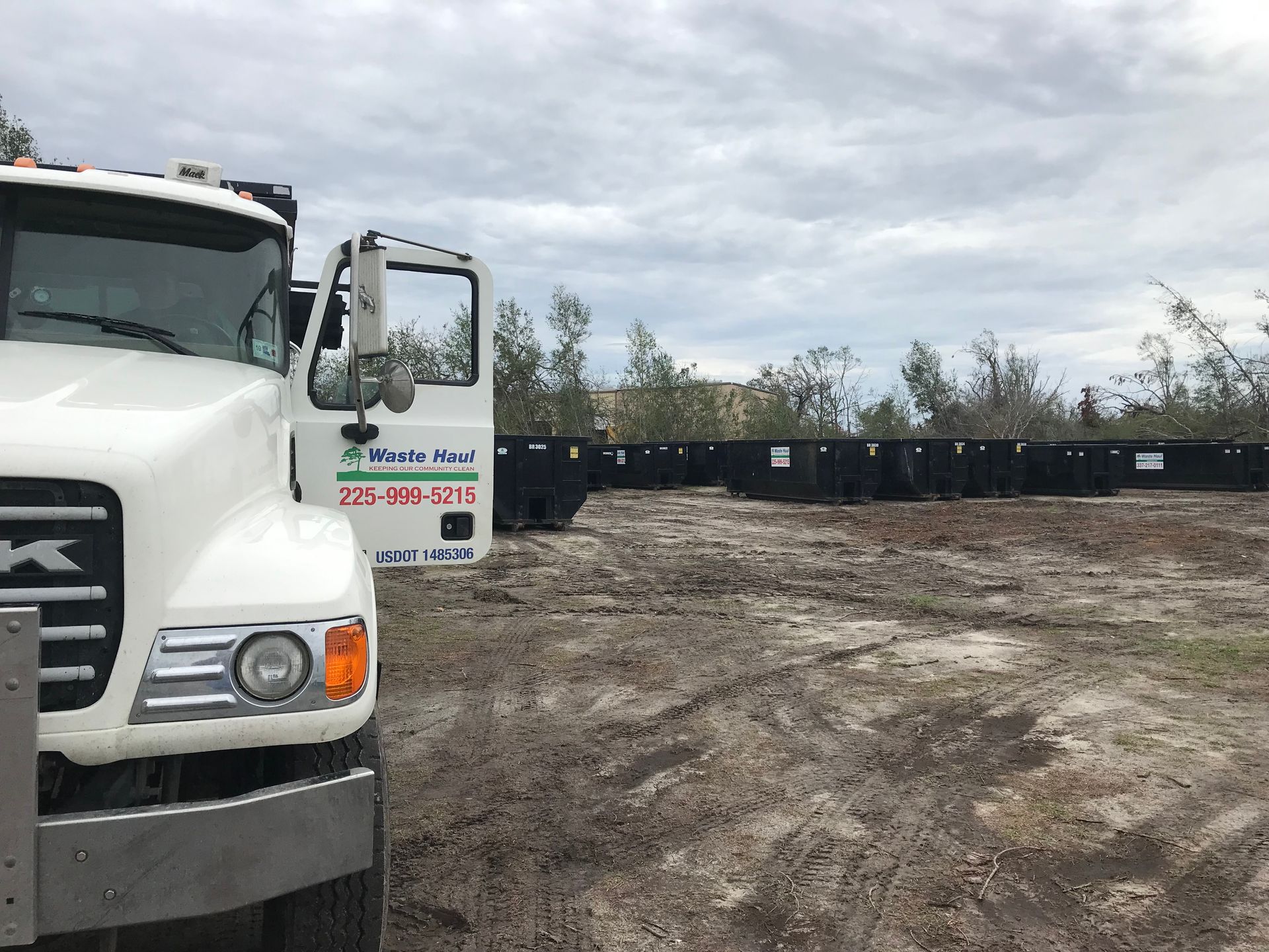 White truck parked at a muddy construction site under a cloudy sky.