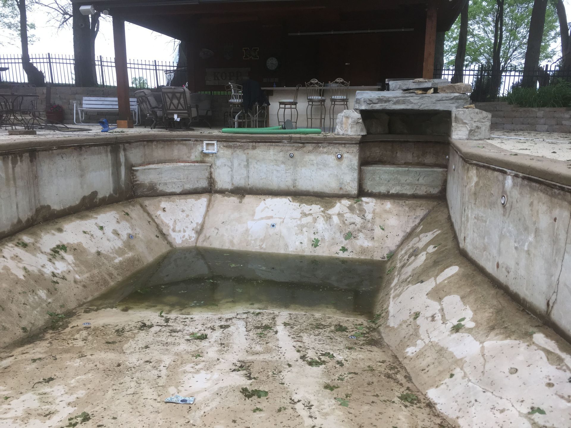 Empty concrete basin under a bridge with shallow water and stained walls