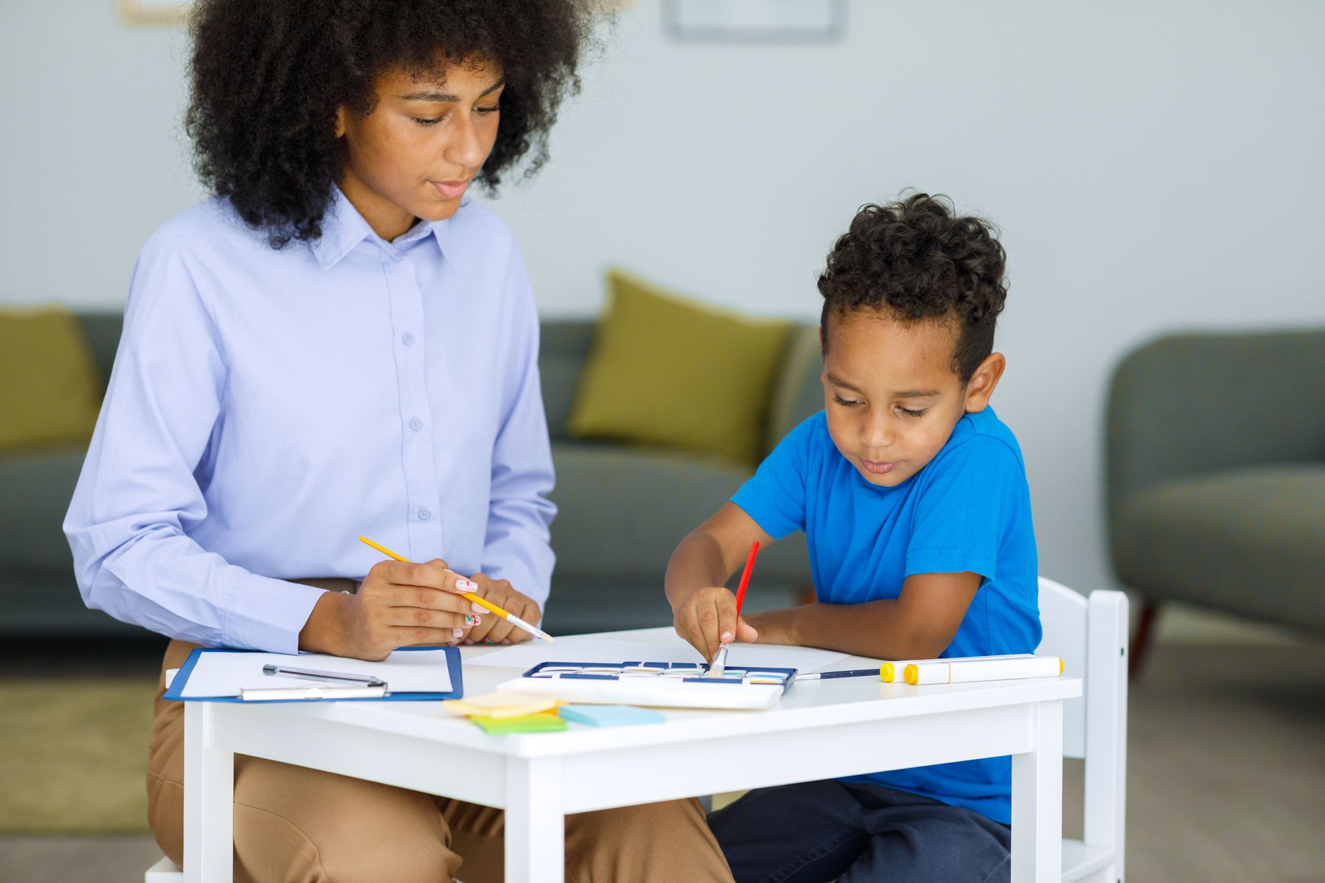 caregiver supporting child with learning activity at home