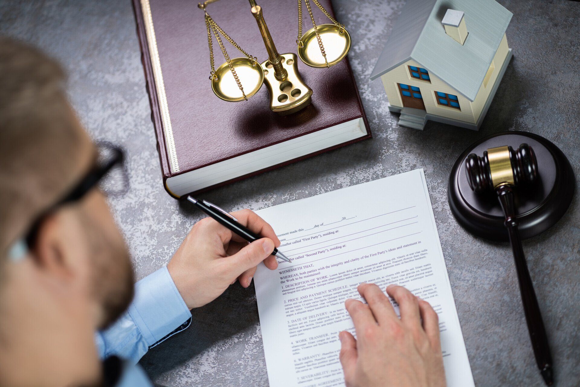 A man is writing on a piece of paper with a pen.