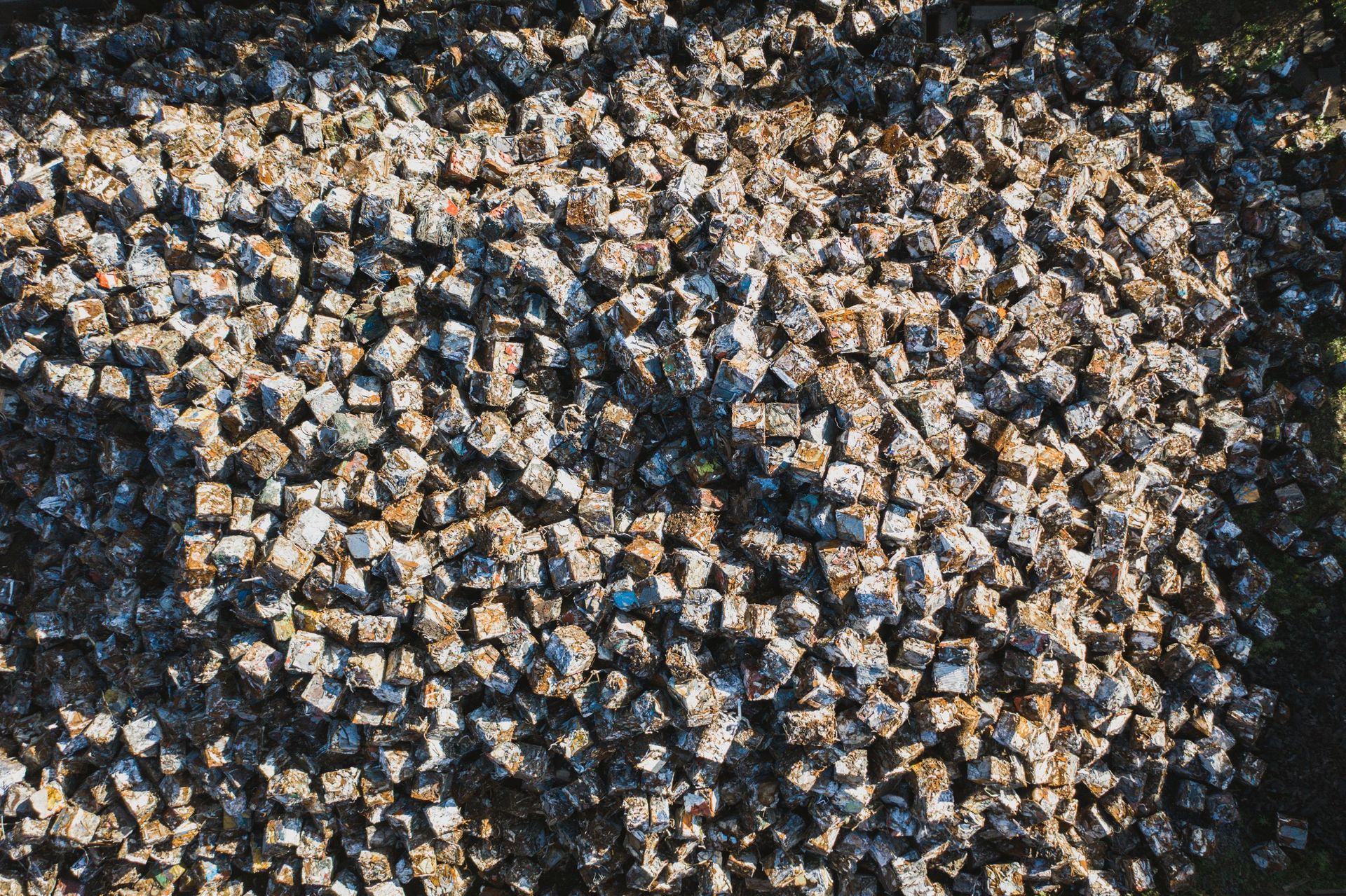 Aerial view of a dense cluster of white and gray rocks or debris on dark ground