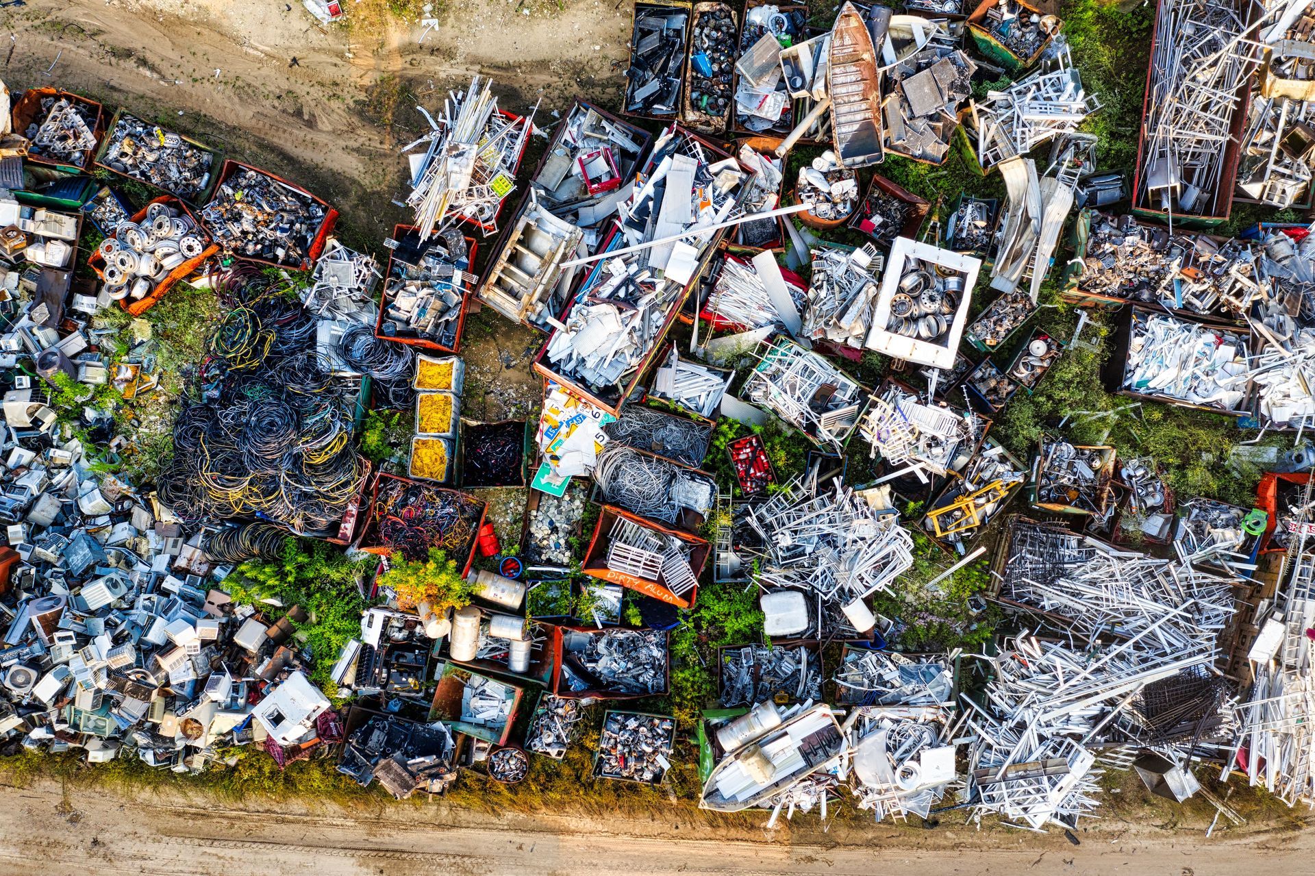 Aerial view of a crowded landfill with piles of mixed trash and debris among dirt paths.