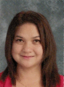 Woman with brown hair smiling, wearing a pink top.