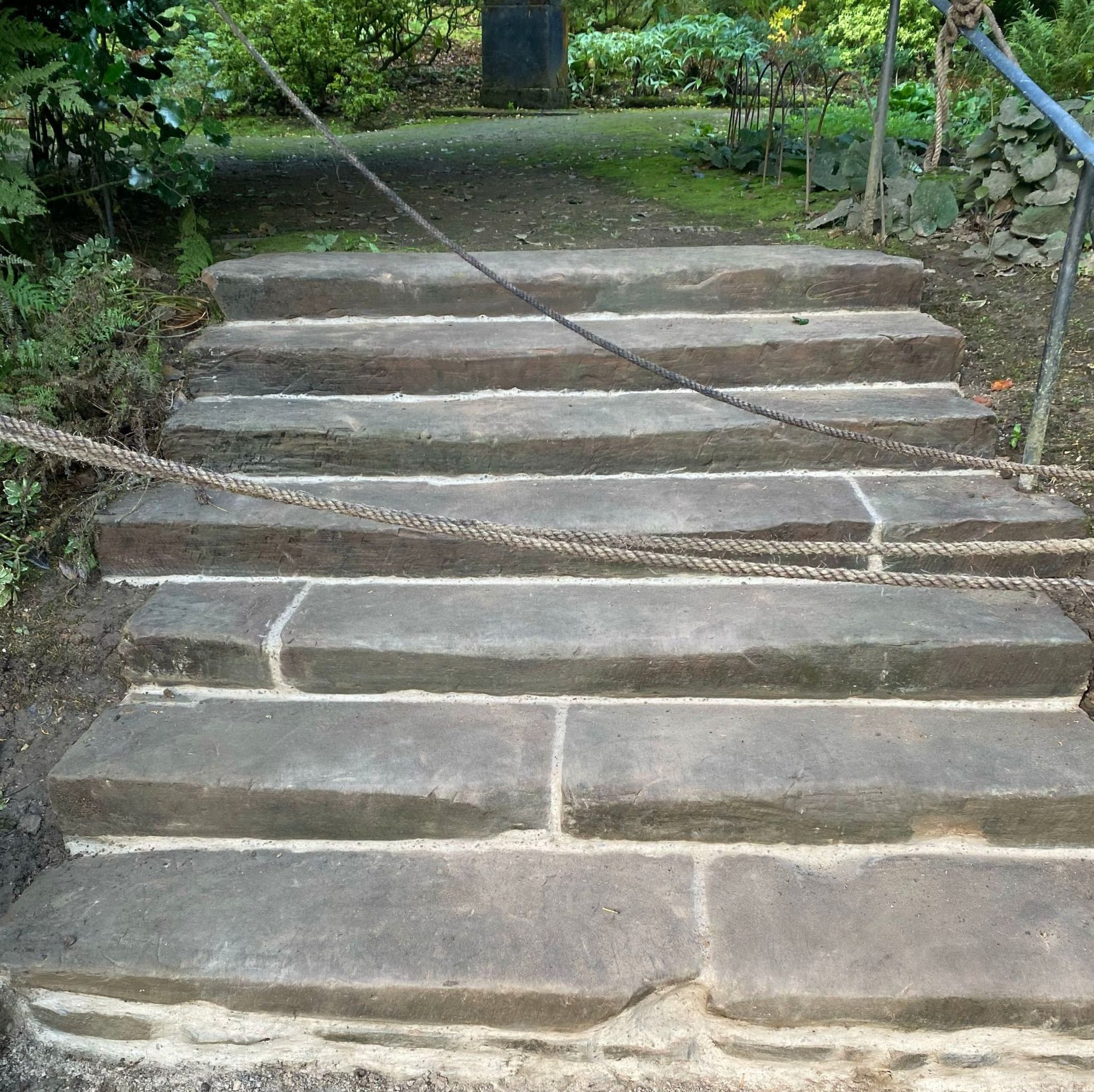 A set of stone stairs with a chain between them After repair