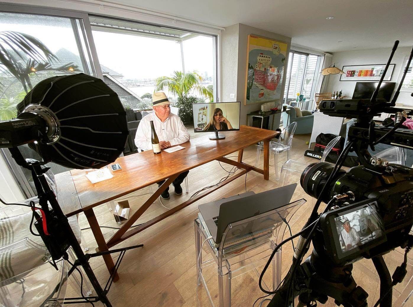 Bob Campbell table, being filmed. Lighting equipment, camera, and interior setting with large window visible.