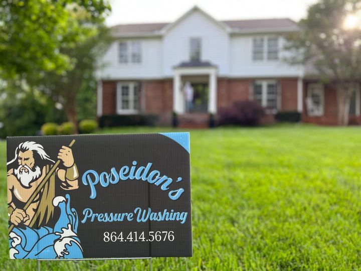 Poseidon's Pressure Washing sign on a lawn in front of a white house