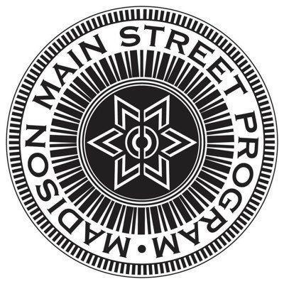 Circular black-and-white Main Street Program logo with a star-like emblem in the center.