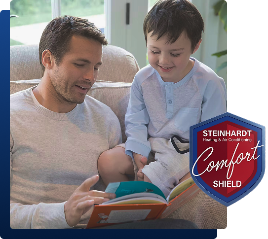 Man and child reading a book on a couch, with a Steinhardt Comfort Shield badge overlay