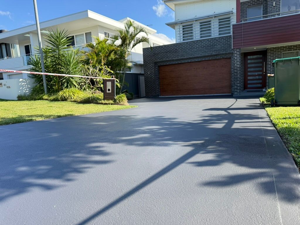 Modern house with a driveway, garage, and palm trees under a blue sky Modern house with a driveway, garage, and palm trees under a blue sky