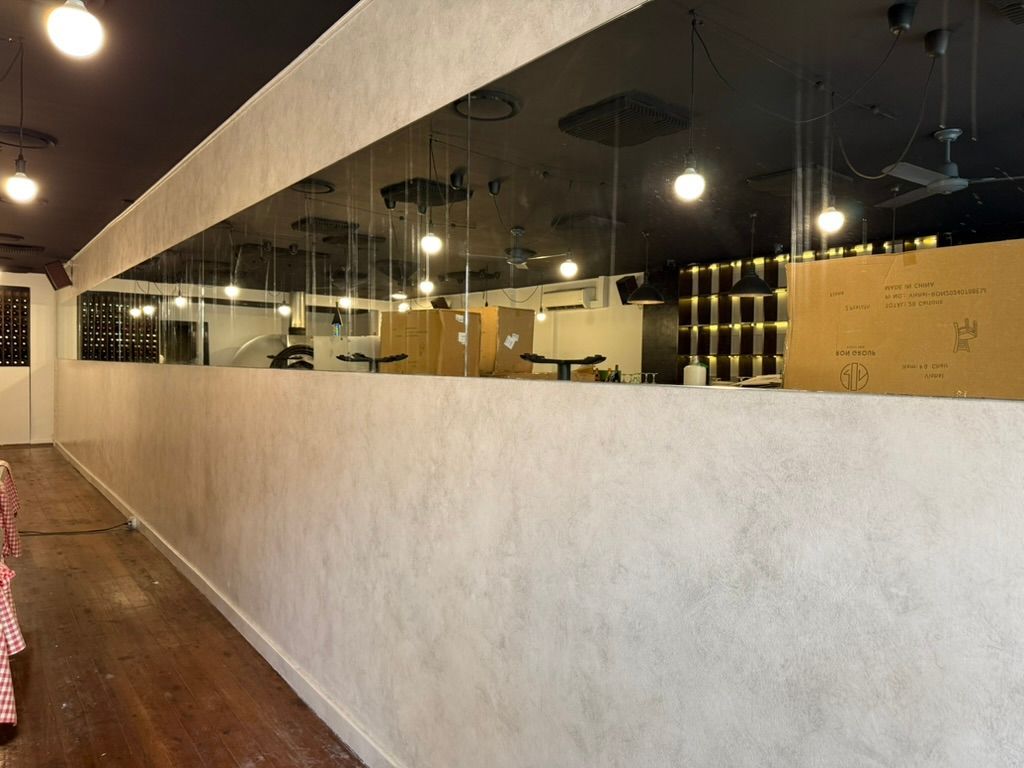 Modern interior with glass walls, wood floor, and ceiling lights in a spacious corridor