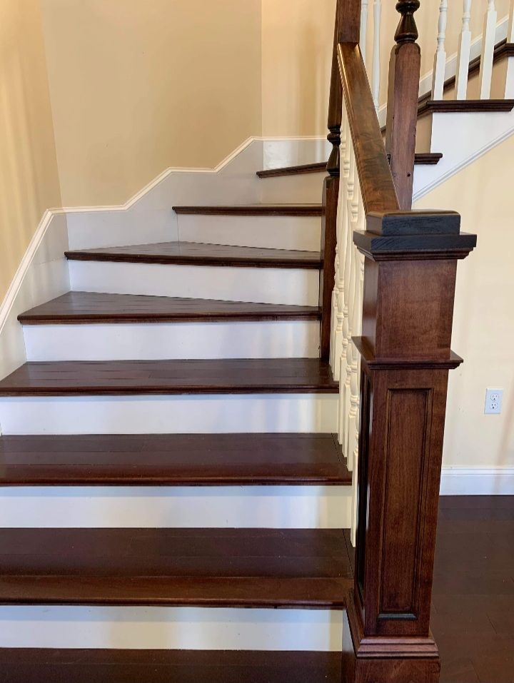 A wooden staircase with white steps and a wooden railing.