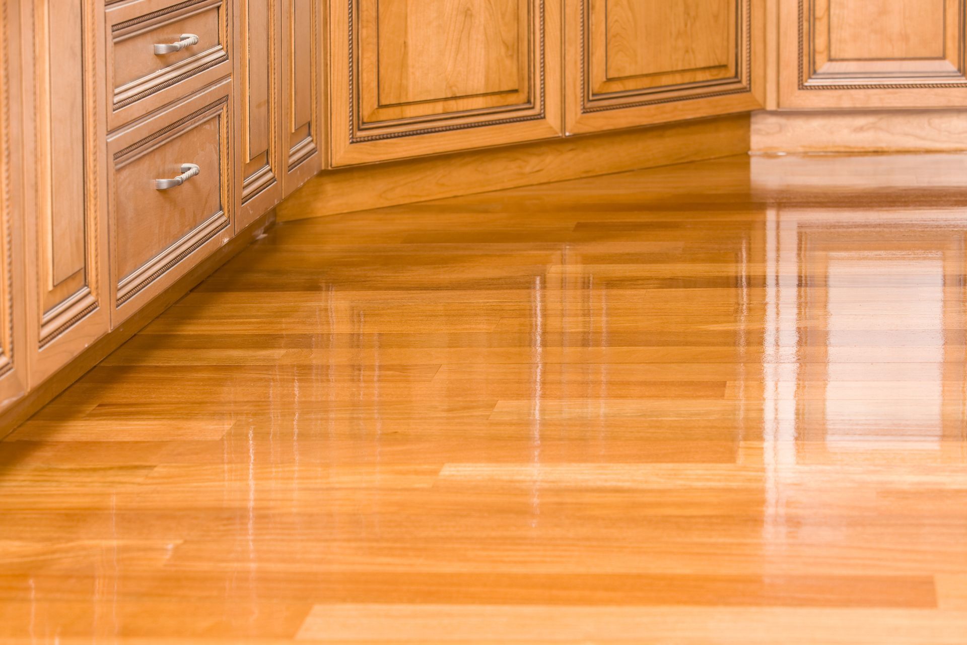 A kitchen with wooden cabinets and a wooden floor.