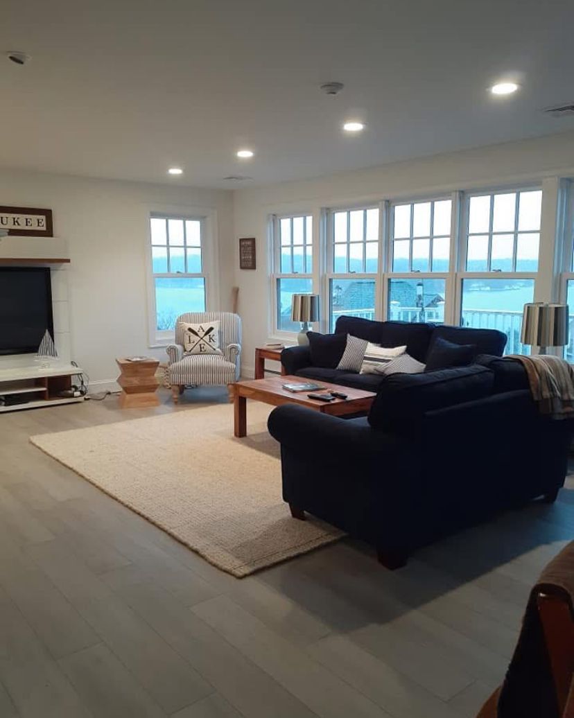 A living room with a couch , chair , coffee table and television.