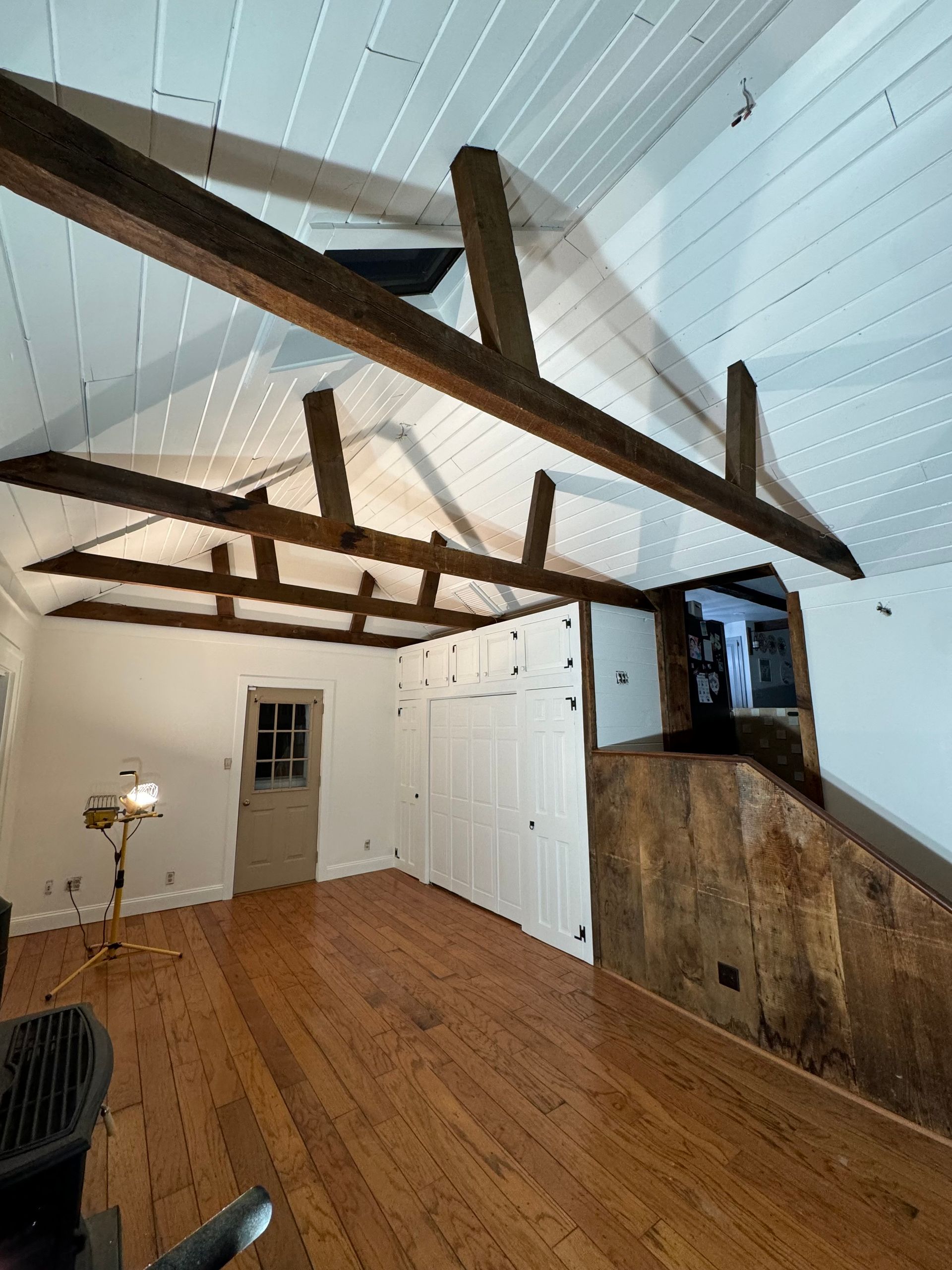 An empty room with wooden floors and white walls