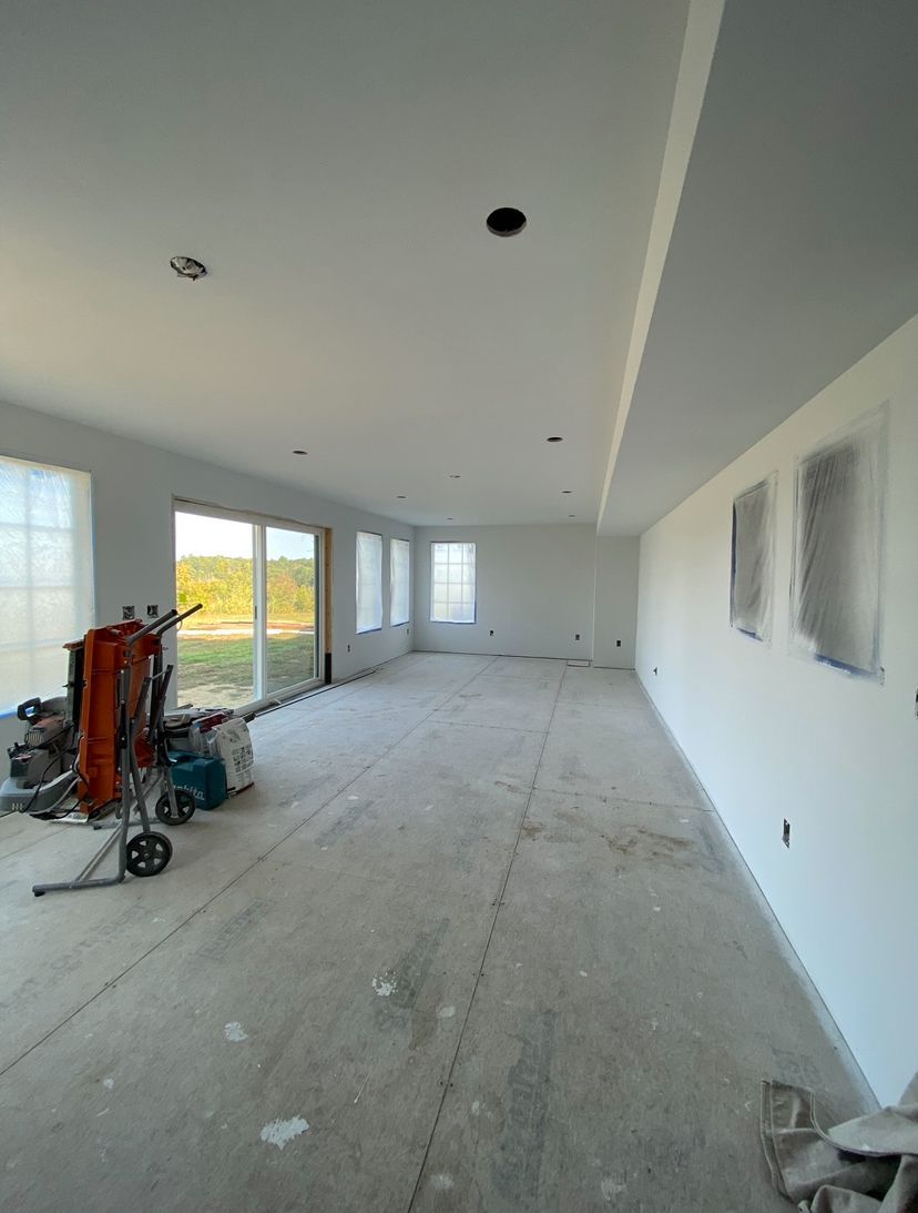 A hallway with black doors and hardwood floors in a house.