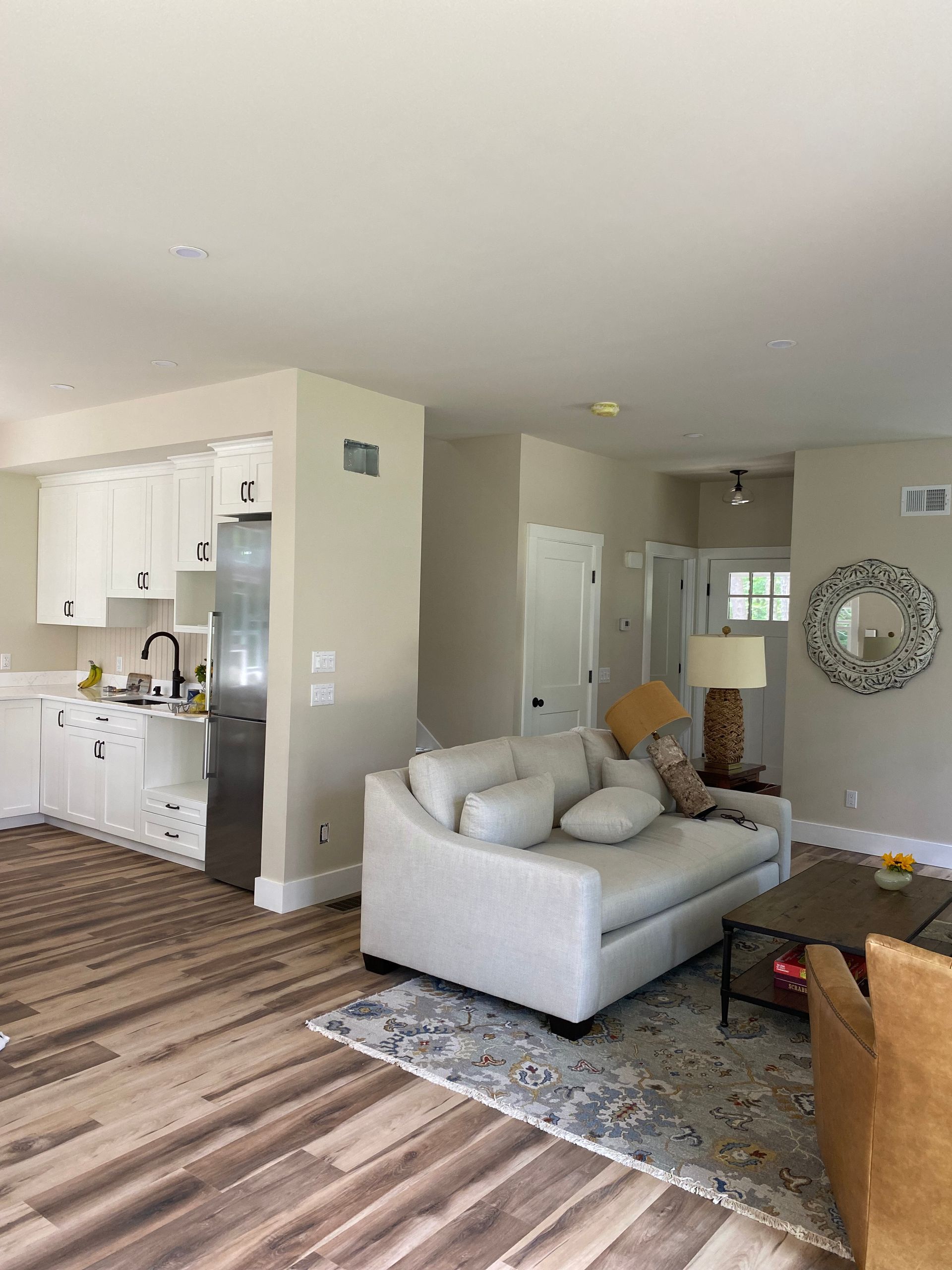 A living room with a couch , chair , coffee table , and kitchen.