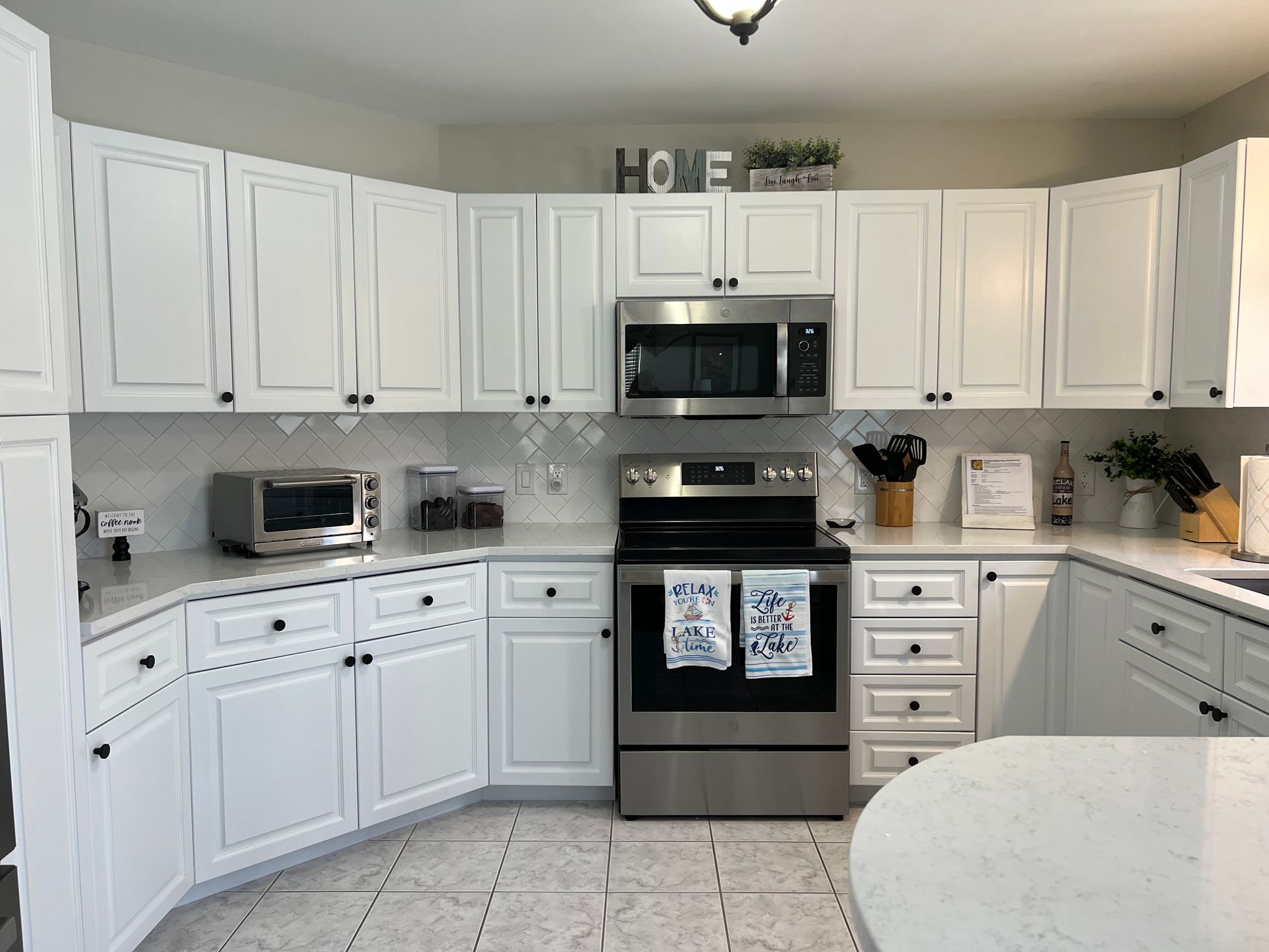 A kitchen with white cabinets and stainless steel appliances.