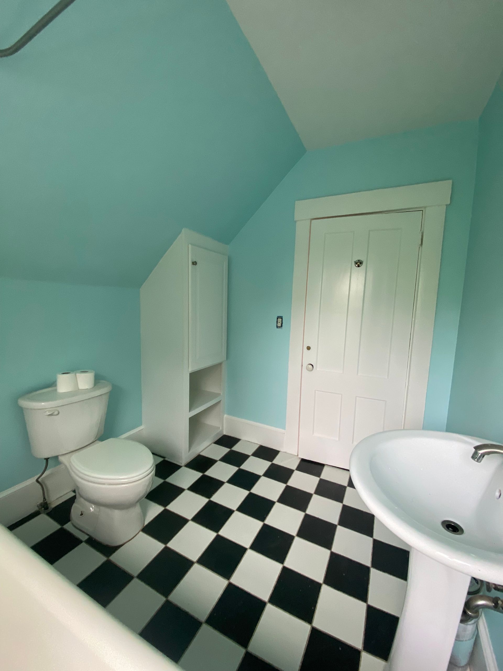 A bathroom with a black and white checkered floor