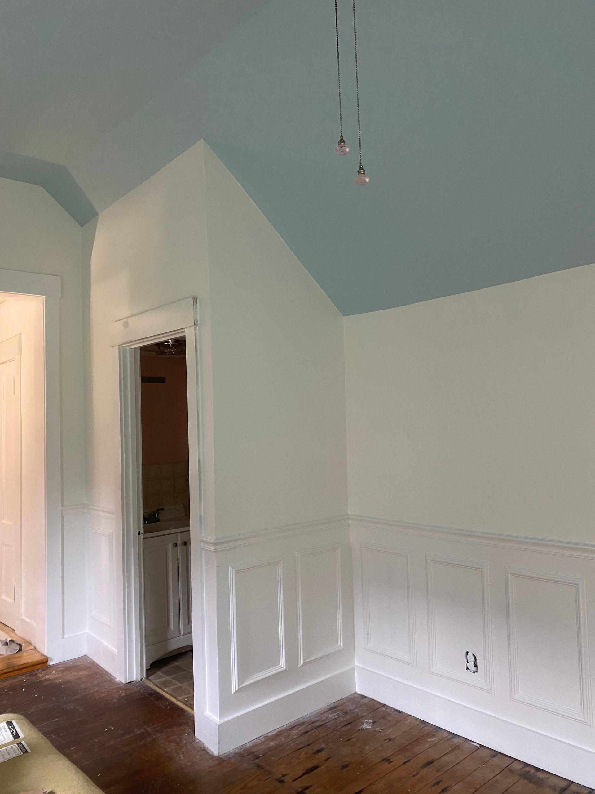 A living room with white walls and a blue ceiling.