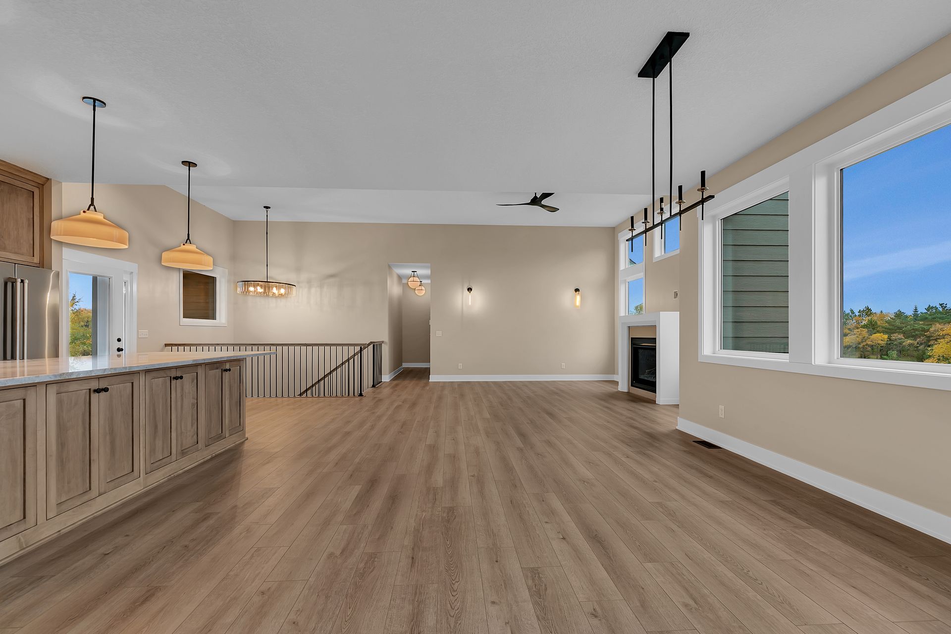 An empty living room with hardwood floors and a kitchen.