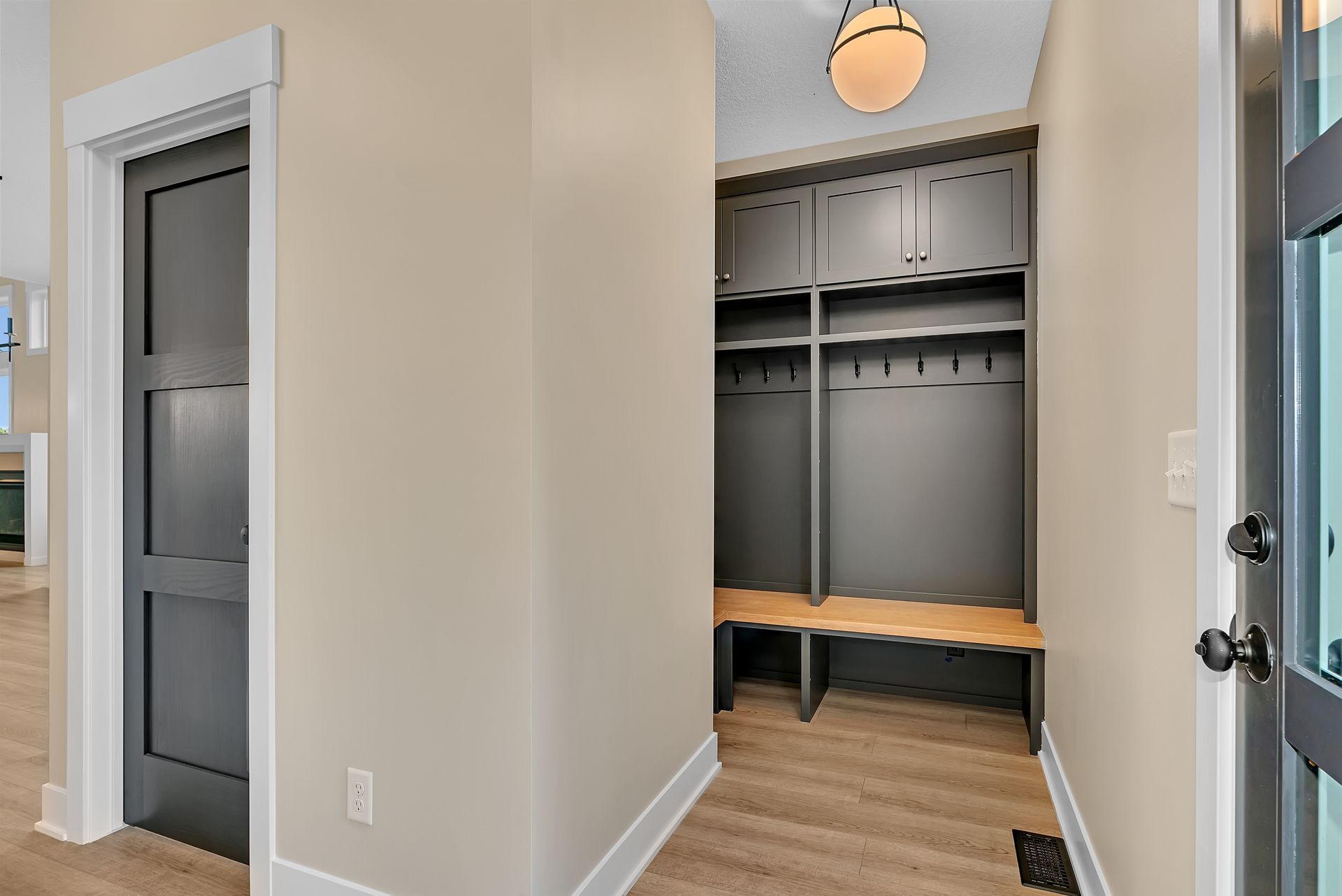 A hallway in a house with a closet and a bench.