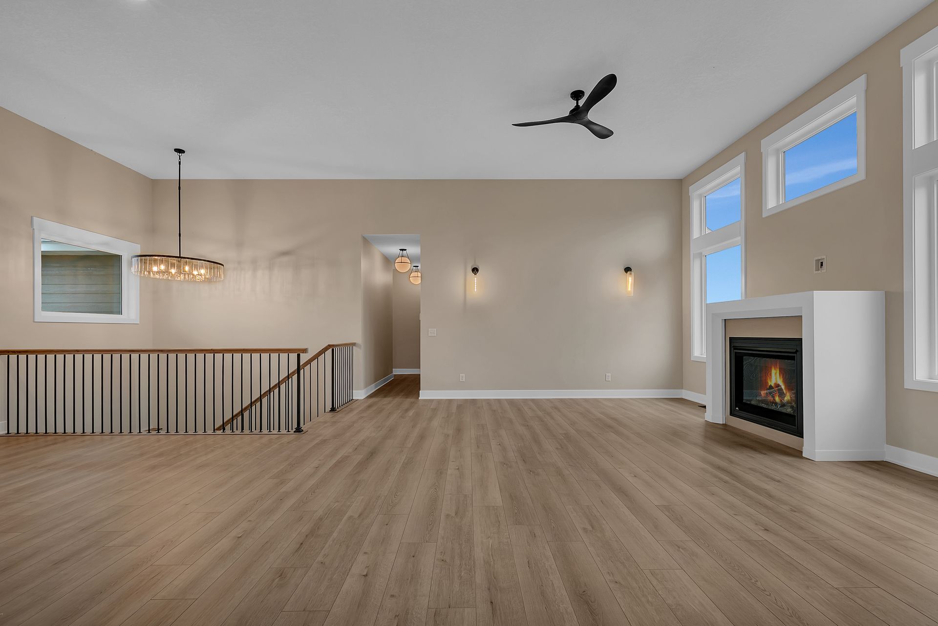An empty living room with a fireplace and a ceiling fan.