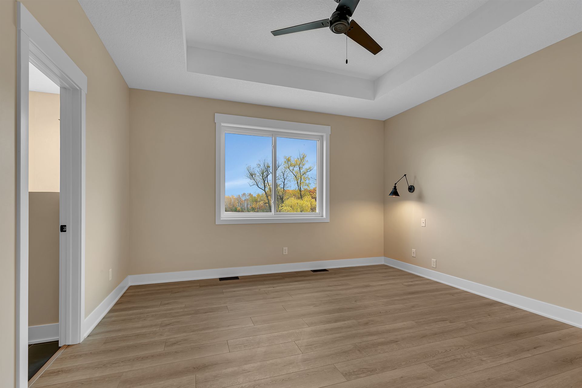 An empty room with a ceiling fan and a window