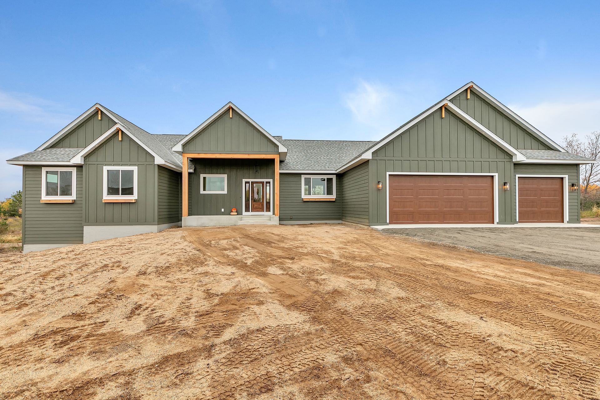 A large house is sitting in the middle of a dirt field.
