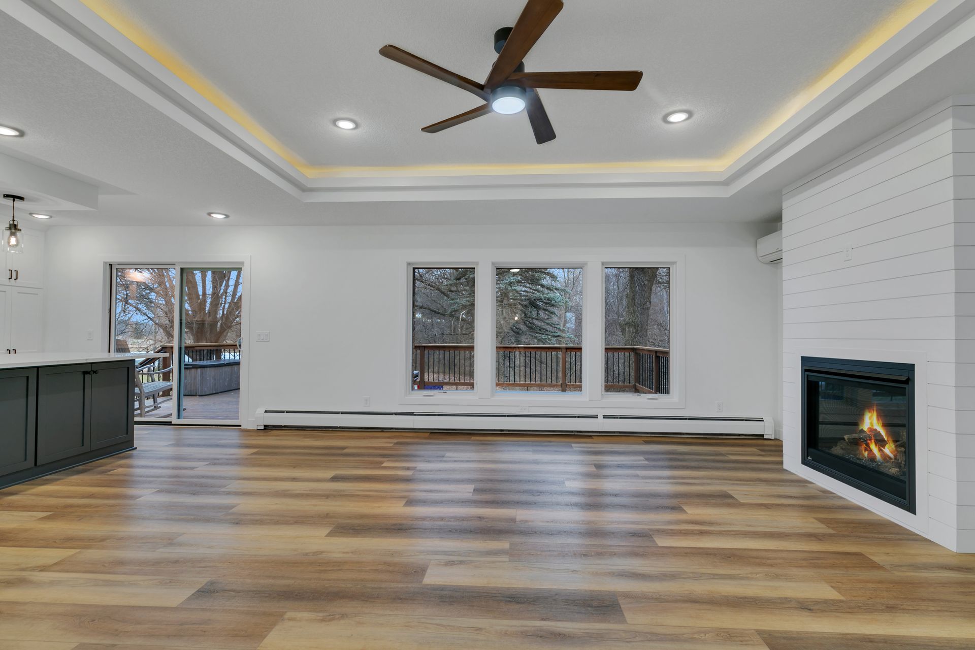 An empty living room with a fireplace and ceiling fan