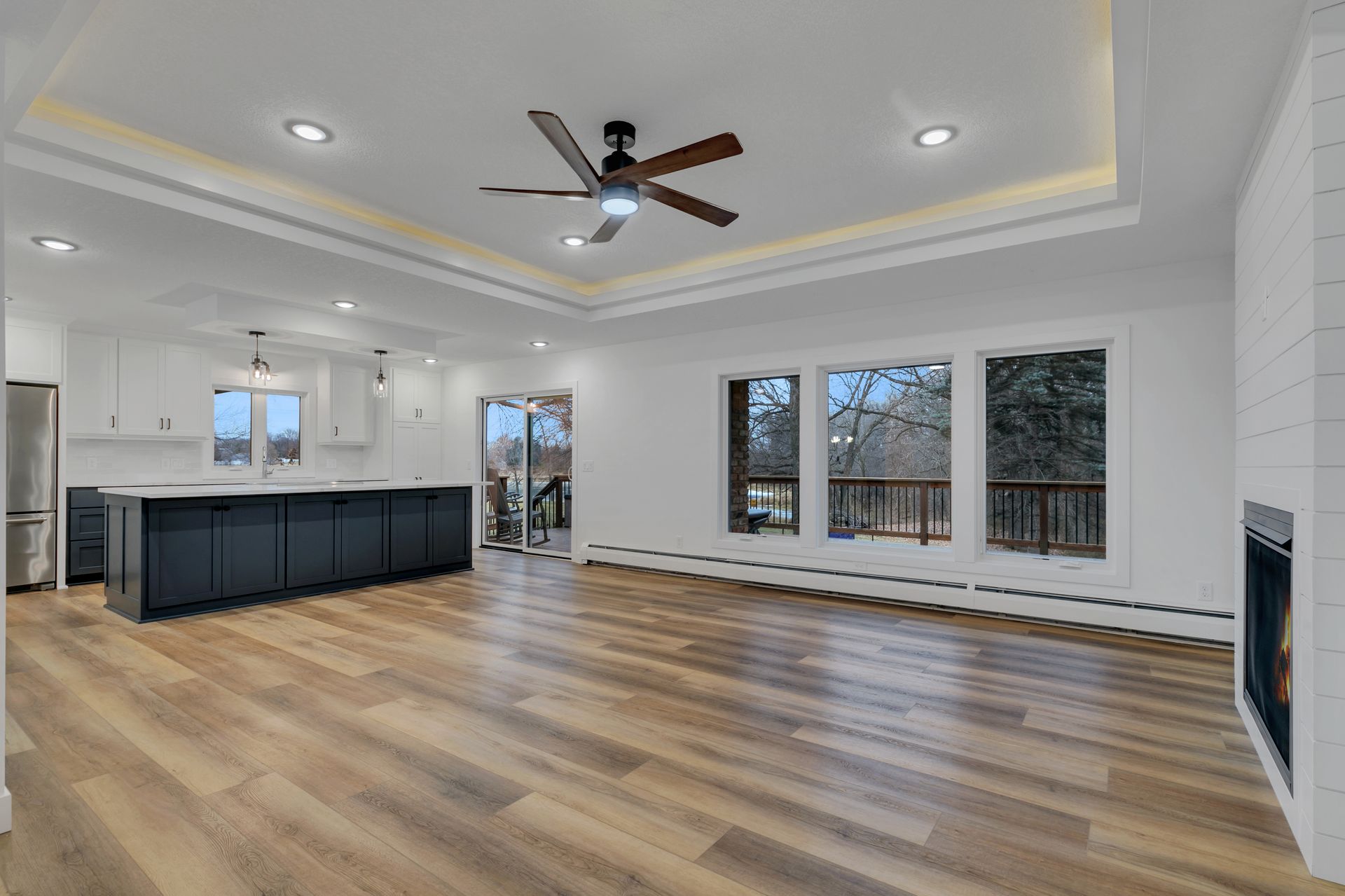 An empty living room with hardwood floors and a ceiling fan.