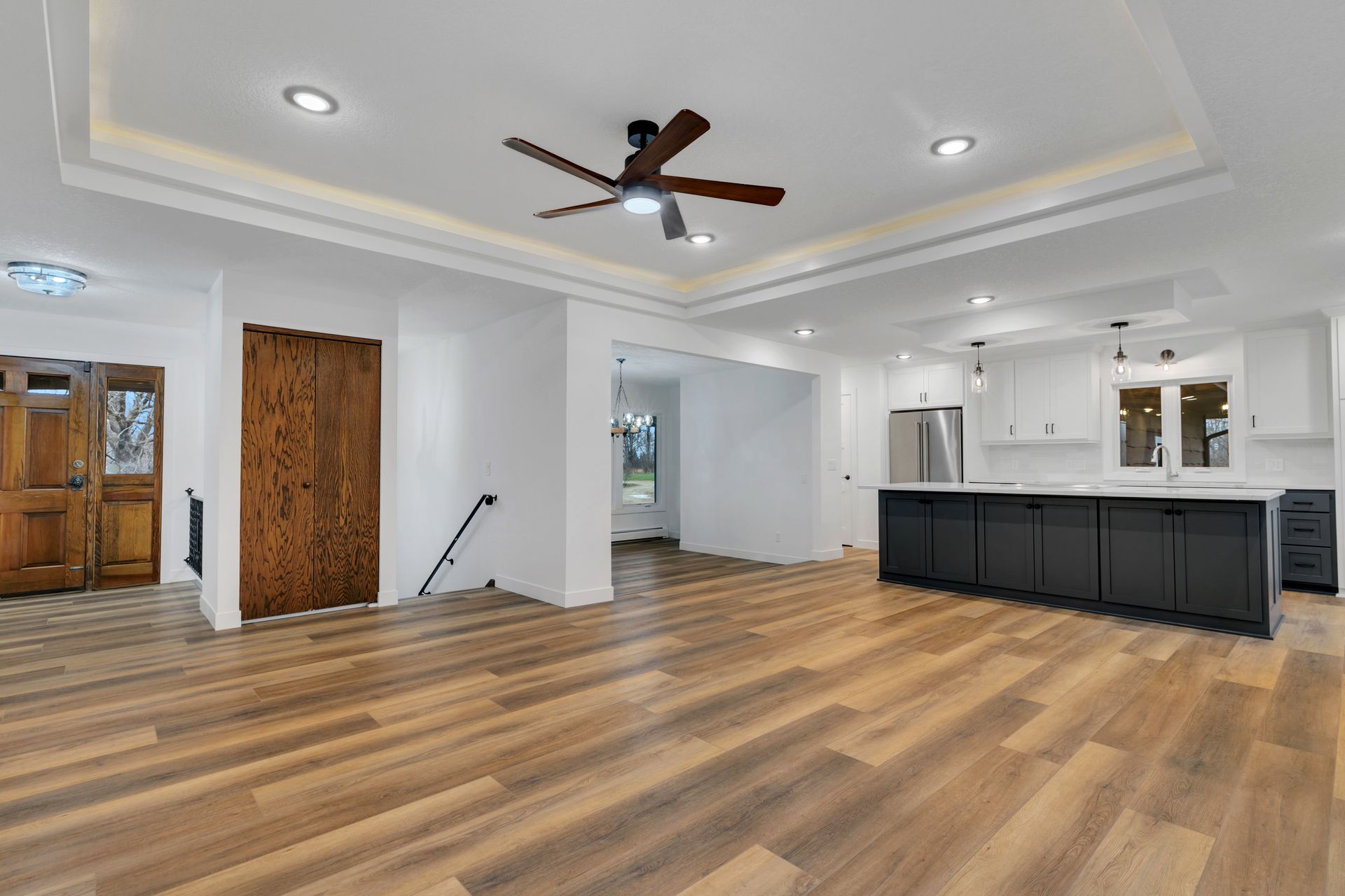 A living room with hardwood floors and a ceiling fan.
