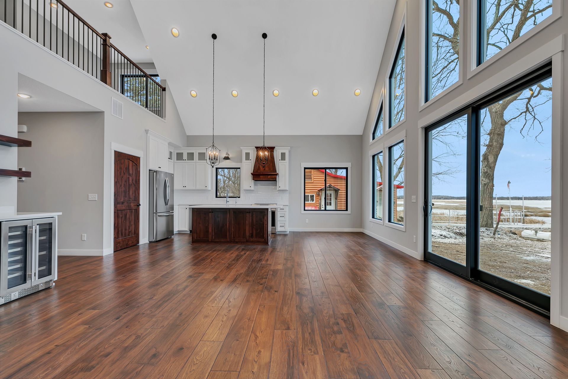 A large empty room with hardwood floors and lots of windows.