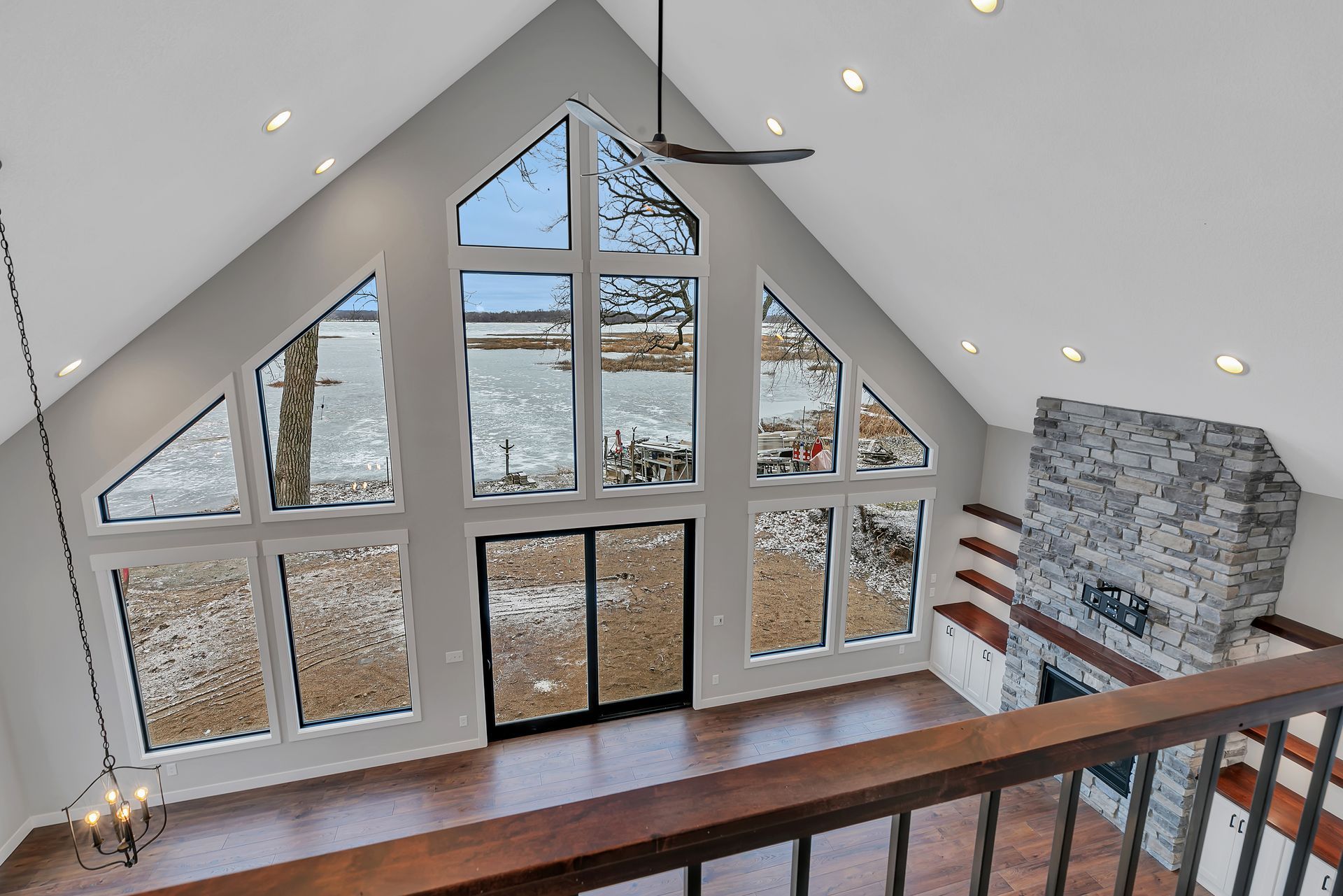 A living room with a lot of windows and a fireplace.