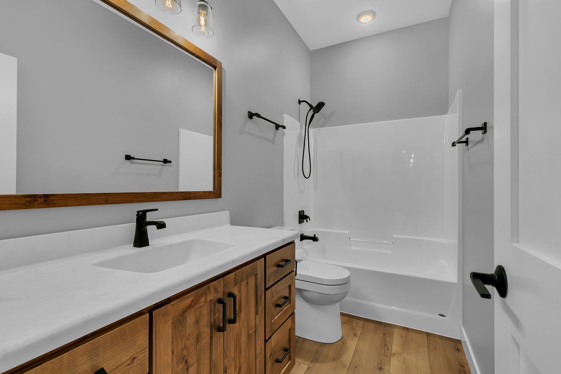 A bathroom with a sink , toilet , bathtub and mirror.