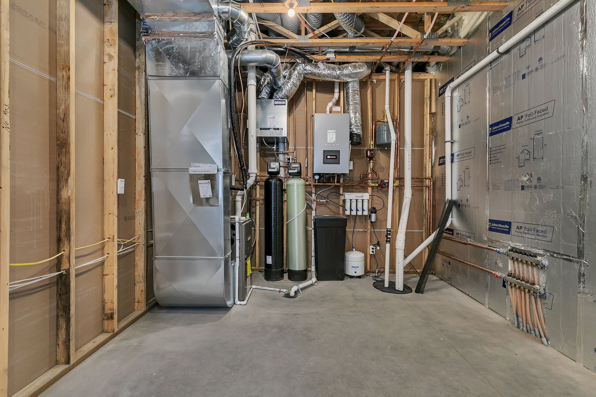A basement with a lot of pipes and a heater.