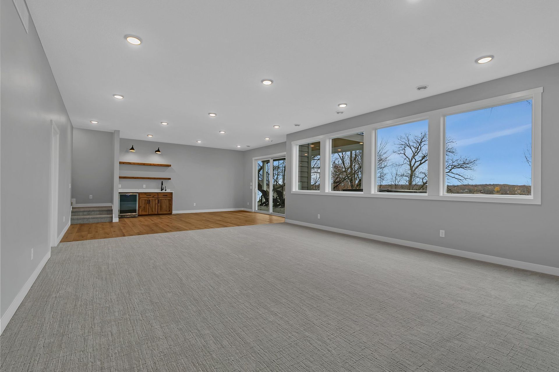 A large empty room with a lot of windows and carpet.