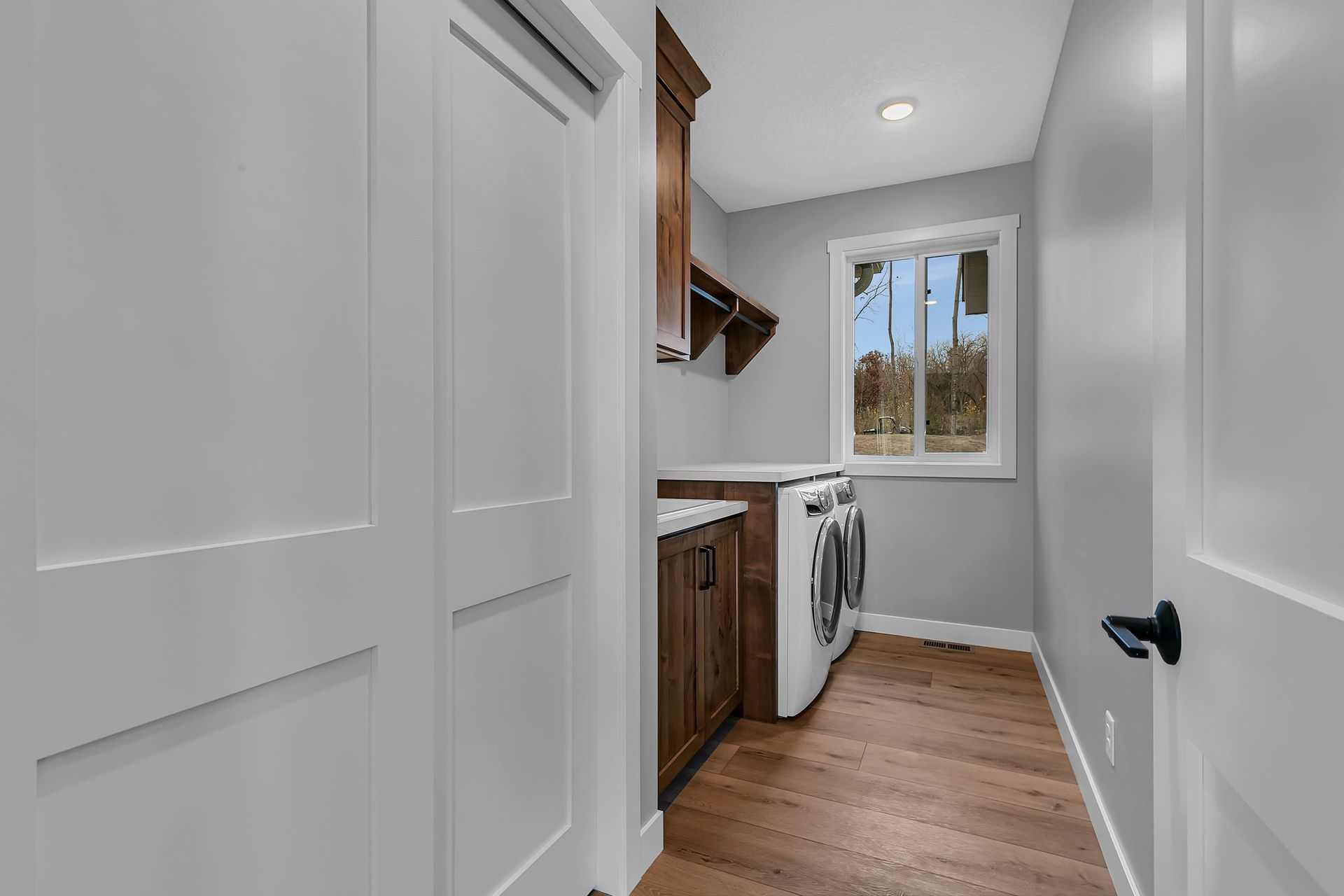 A laundry room with a washer and dryer and a window.