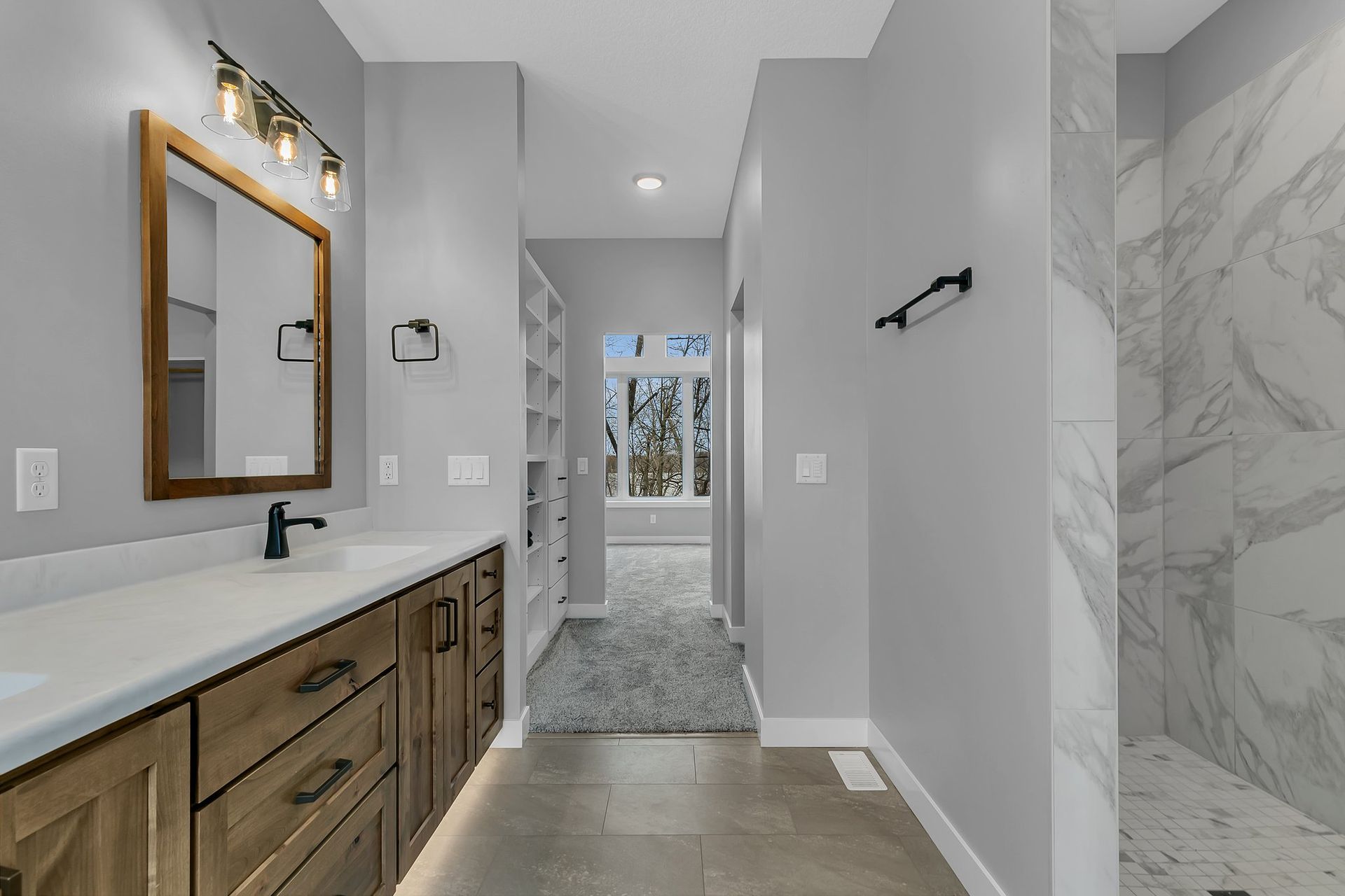 A bathroom with a sink , mirror , and walk in shower.